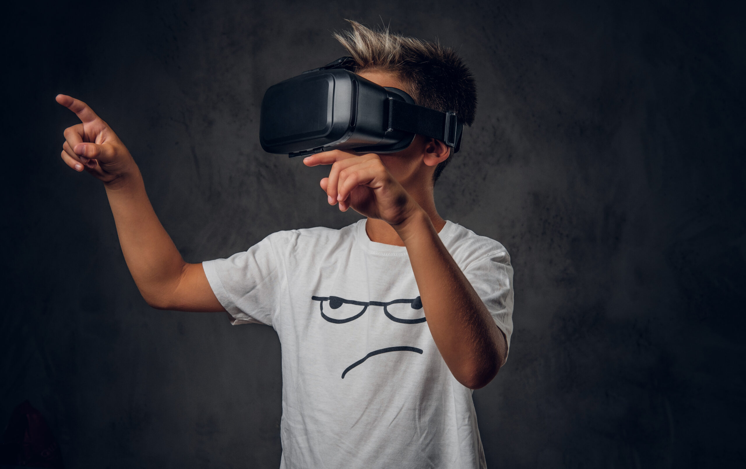 boy wearing a virtual reality headset and pointing to the left